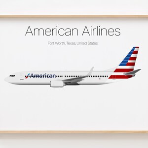 May include: A white airplane with a blue and red American Airlines logo on the side. The tail of the plane is painted with the American flag. The plane is on a white background with the text "American Airlines" and "Fort Worth, Texas, United States" below the plane.