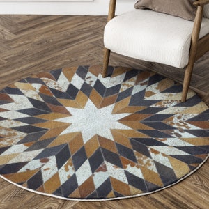 Puede incluir: Una alfombra redonda de piel de vaca multicolor con un patrón de estrella en tonos marrones, blancos y negros. La alfombra está hecha de cuero y tiene un aspecto desgastado.