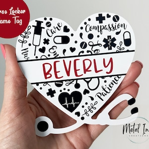 May include: A heart-shaped nurse locker name tag with the name "Beverly" in red. The tag features medical symbols and the words "Care", "Compassion", and "Patience". A stethoscope design is attached to the bottom.