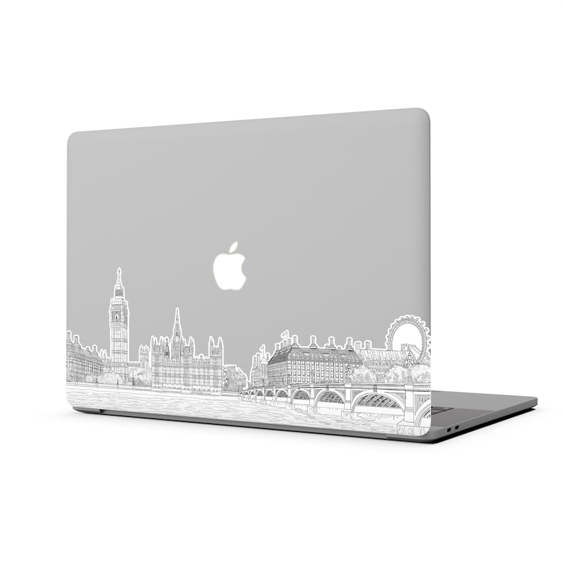 K&ouml;nnte beinhalten: Ein silberner Laptop mit einer Schwarzwei&szlig;-Zeichnung der Londoner Skyline auf dem Deckel. Die Zeichnung zeigt Big Ben, das London Eye und das Houses of Parliament.
