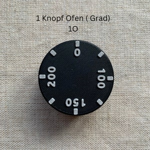 May include: A black oven dial with white markings for temperature settings. The dial has numbers 0, 100, 150, and 200. The text "1 Knopf Ofen (Grad)" and "10" are above the dial.