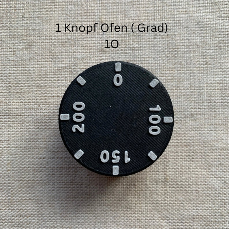 May include: A black oven dial with white markings for temperature settings. The dial has numbers 0, 100, 150, and 200. The text "1 Knopf Ofen (Grad)" and "10" are above the dial.