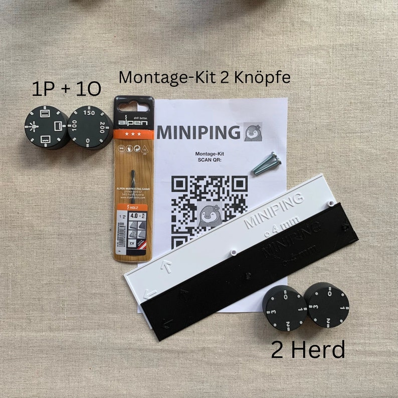 May include: A kit for a stove with the text "Montage-Kit 2 Kn&ouml;pfe" and "MINIPING". Includes two black and white control knobs, a drill bit, and a white and black ruler. The kit also includes a QR code and the text "2 Herd".