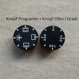 May include: Two black circular control knobs with white markings. One knob has symbols for oven functions, the other displays temperature settings from 0 to 200. The text "Knopf Programm + Knopf Ofen (Grad)" is above the knobs.