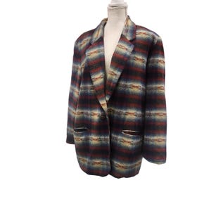 May include: A multi-colored blazer with a plaid pattern. The jacket features a notched collar, two front pockets, and a single-button closure. The color palette includes shades of red, blue, tan, and black.