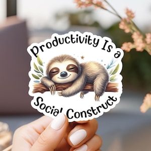 May include: A sticker featuring a cartoon sloth resting on a branch. The sloth is brown and tan with closed eyes, and the sticker has the text "Productivity Is a Social Construct" in a circular design.