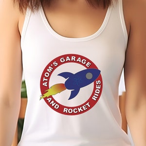 May include: White tank top with a red circle logo featuring a blue rocket with a yellow flame and the text "Atom's Garage and Rocket Rides".