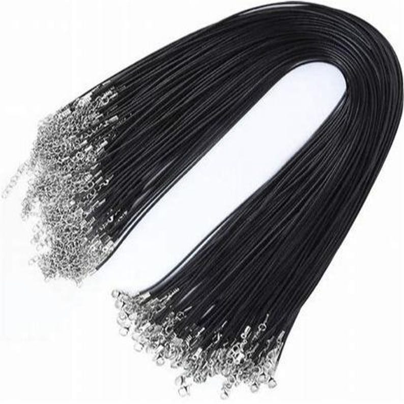 May include: A bulk pack of 50 black waxed cotton cords with silver lobster clasps. Each cord is approximately 18 inches long.