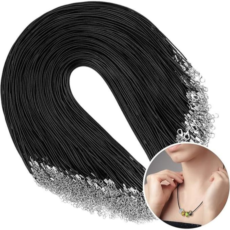 May include: A bulk pack of 100 black waxed cotton cords with silver lobster clasps. The cords are arranged in a circle, with the clasps visible at the bottom.