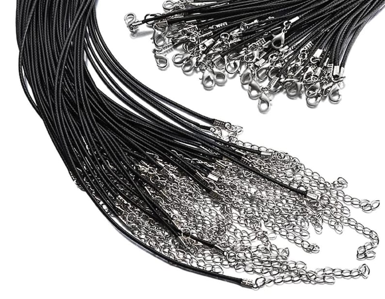 May include: A bulk pack of black leather cord necklaces with silver lobster clasps. The cords are arranged in a fan shape, with the clasps at the top.