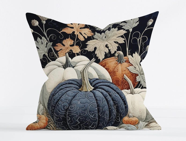 May include: A square throw pillow featuring a dark background with a pattern of pumpkins in shades of navy blue, white, and orange. The design includes intricate swirling line details on the pumpkins and light-colored foliage and vine accents.