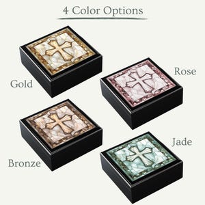 K&ouml;nnte beinhalten: Vier Holzkisten mit einem Buntglaskreuz-Design. Die Kisten sind in Gold, Bronze, Rose und Jade erh&auml;ltlich.