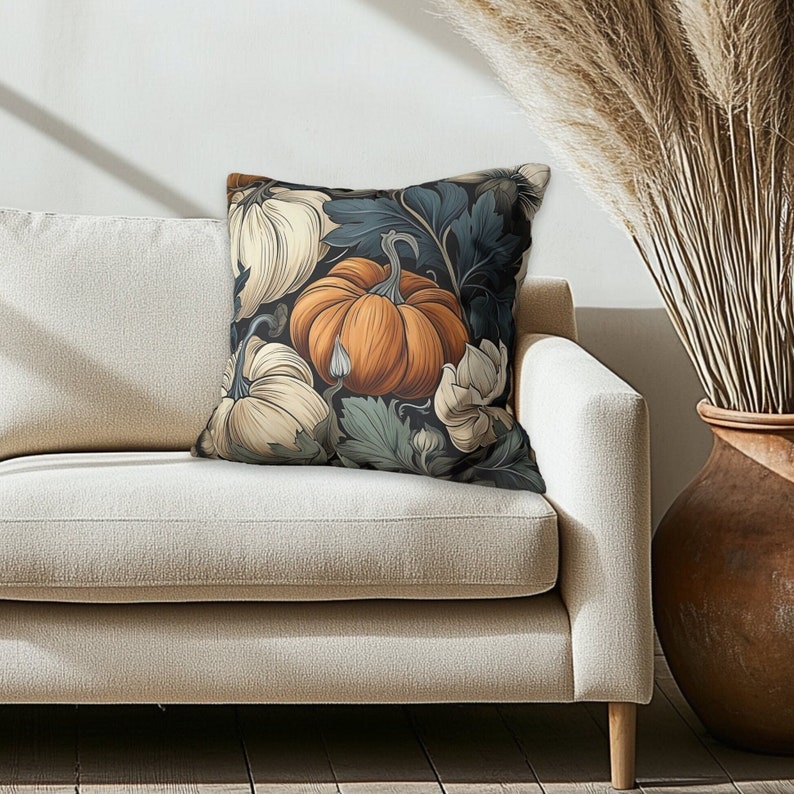 May include: A square throw pillow featuring a detailed botanical illustration of pumpkins and foliage. The design showcases a central orange pumpkin surrounded by cream-colored pumpkins and dark blue-green leaves against a dark background.
