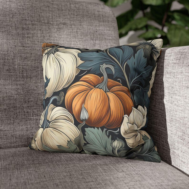 May include: A square throw pillow featuring a dark background with a repeating pattern of orange and cream-colored pumpkins, accompanied by dark teal and sage green foliage and leaves, creating a detailed botanical illustration across the fabric.