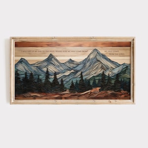 Op de afbeelding: Houten ingelijste kunstafdruk met een berglandschap in blauwe en groene tinten. Het kunstwerk bevat de tekst: "I WILL LIFT UP MY EYES TO THE HILLS. WHERE DOES MY HELP COME FROM? MY HELP COMES FROM THE LORD."