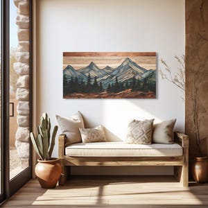 Op de afbeelding: Een houten wandkunstwerk met een berglandschap met dennenbomen in blauwe, groene en bruine tinten. Het kunstwerk bevat tekst bovenaan. Het wordt tentoongesteld boven een houten bank met beige kussens en kussens.