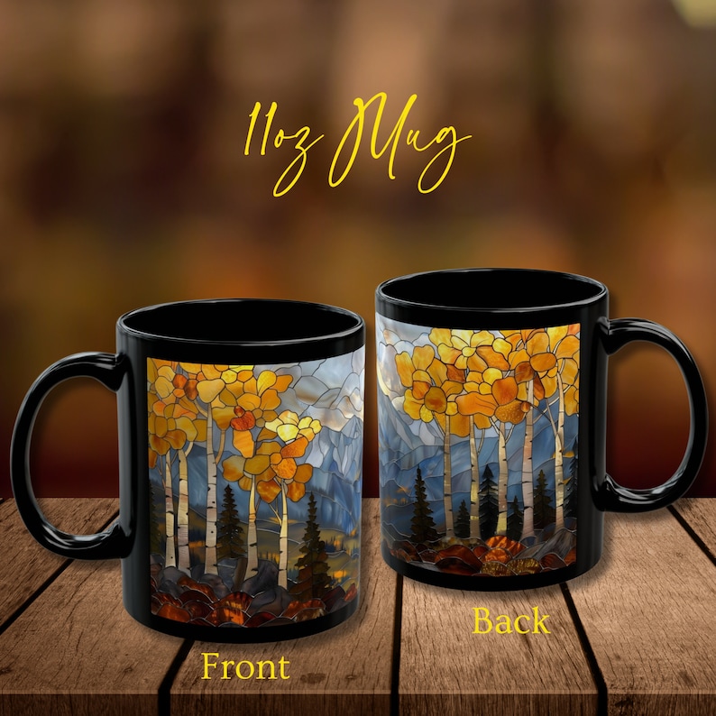 May include: Black 11oz mug with a stained glass design of a forest scene with yellow, orange, and brown trees. The front of the mug shows the trees in the foreground with mountains in the background. The back of the mug shows the trees from a different angle.