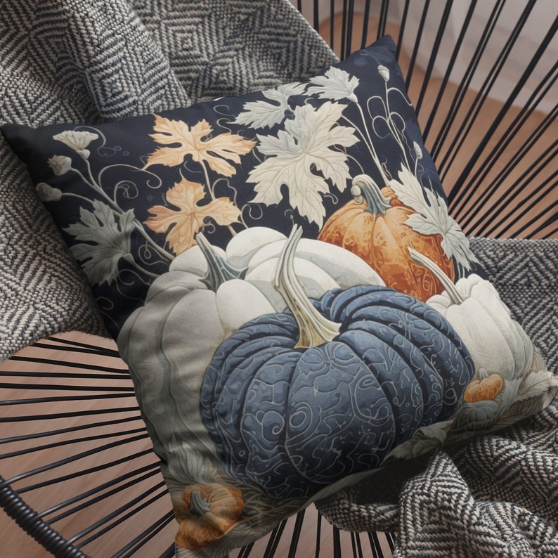 May include: A square throw pillow featuring a dark navy background with a botanical print of pumpkins in shades of orange, white, and deep blue. The design includes intricate swirling vine patterns and detailed leaves in cream and light orange tones.