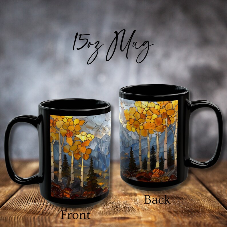 May include: Black ceramic 15oz mug with a stained glass design of a forest scene with trees and mountains. The front of the mug shows a close-up of the trees, while the back shows a wider view of the scene.