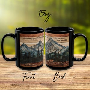 May include: Two black 15oz ceramic mugs featuring a mountain and forest landscape graphic. The front mug displays the text 'I will lift up my eyes to the hills', while the back mug displays 'My help comes from the LORD' and 'Psalm 121:1-2'.