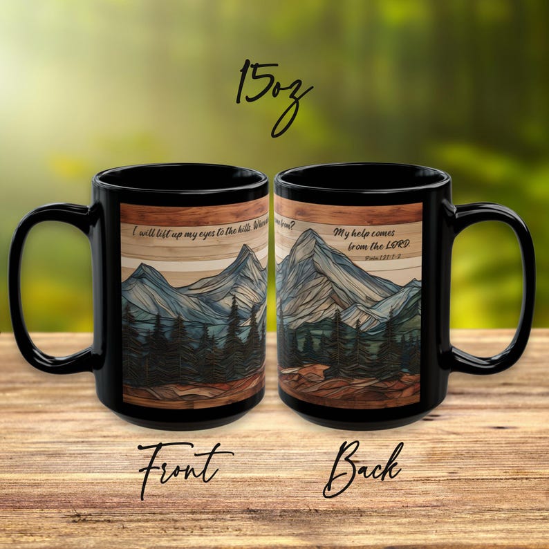 May include: Two black 15oz ceramic mugs featuring a mountain and forest landscape graphic. The front mug displays the text 'I will lift up my eyes to the hills', while the back mug displays 'My help comes from the LORD' and 'Psalm 121:1-2'.