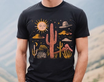 以下が含まれることがあります： 砂漠のシーンが描かれた黒いTシャツ。サボテン、顔のある太陽、星、帽子が描かれています。
