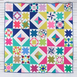 May include: A colourful quilt featuring a variety of geometric patterns, including stars, diamonds, and squares. The quilt is made with a white background and features bright colours such as pink, blue, green, yellow, and red.