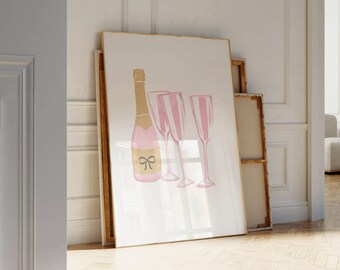 May include: A white framed print featuring a pink champagne bottle and two pink champagne flutes with gold accents. The bottle has a pink bow on the neck.