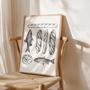 Puede incluir: Una ilustraci&oacute;n en blanco y negro de una baguette, tres panes, un pez y una hogaza de pan redonda. La ilustraci&oacute;n est&aacute; impresa sobre un fondo blanco y enmarcada en un marco de madera.