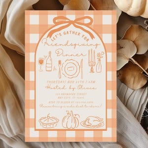 May include: A Friendsgiving dinner invitation with a peach and white gingham pattern. The invitation features the text "Let's Gather for Friendsgiving Dinner" and includes illustrations of food and drink. A white pumpkin and fall foliage are in the background.