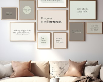 May include: A collection of framed wall art with inspirational quotes, including "Progress is still progress" and "Slow is a valid pace." The frames are arranged above a beige sofa with brown pillows and a wooden coffee table. The room has a neutral color palette.