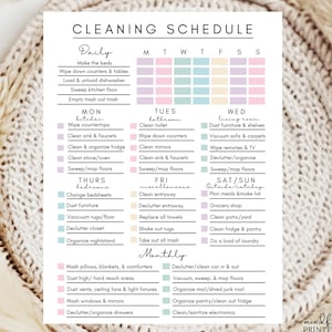 May include: A printed cleaning schedule with pastel color-coded sections for daily, weekly, and monthly tasks. The schedule includes tasks like making beds, cleaning bathrooms, and organizing. The text "CLEANING SCHEDULE" is at the top.
