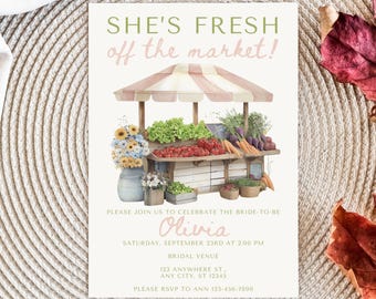 Op de afbeelding: Een uitnodiging voor een bruidsdouche met een aquarel illustratie van een marktkraam. De kraam is gevuld met producten en bloemen. De tekst luidt "SHE'S FRESH off the market!" en bevat evenementdetails.