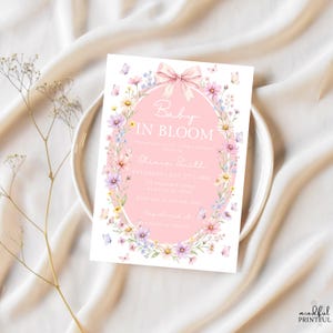 May include: A baby shower invitation with the text "Baby in Bloom" in a pink oval, surrounded by a floral wreath and butterflies. The invitation includes the name Olivia Smith, date, time, and address.