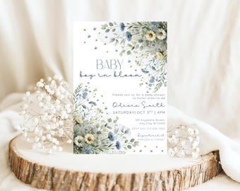 May include: A baby shower invitation with floral accents. The invitation features the words "BABY boy in bloom" in a delicate script. The invitation includes details such as the date, time, location, and RSVP information, all set against a white background.