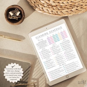May include: A digital tablet shows a cleaning schedule with tasks for each day of the week, in pastel colours. The text reads "Cleaning Schedule". A wooden bowl with gold paper clips and a gold pen are also visible.