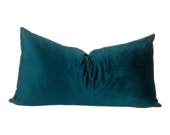 May include: A teal blue rectangular pillow with a soft, velvety texture.