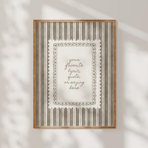 May include: A framed print with a wooden frame. The print features a decorative border and the text "your favorite lyric, quote, or saying here" in a script font. The background has vertical stripes.