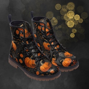 May include: Black lace-up boots with a pumpkin and floral print. The boots have a round toe and a chunky heel.