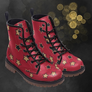 May include: A pair of red and black combat boots with a gold star pattern. The boots have black laces and a black sole.