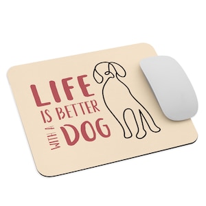 Może przedstawiać: Beżowa podkładka pod mysz z czarnym rysunkiem psa i tekstem "Life is better with a dog" w kolorze czerwonym.