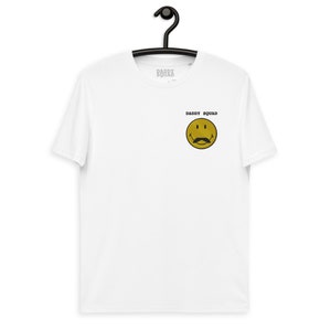 May include: White t-shirt with a yellow smiley face with a moustache and the text "Daddy Squad" printed on the front.