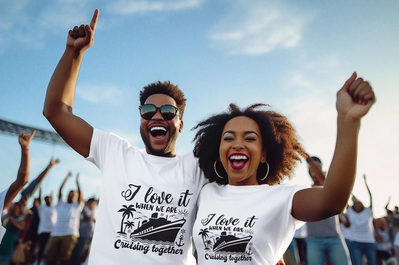 May include: A couple wearing white t-shirts with a cruise ship graphic and the text "I love it when we are cruising together". They are smiling and raising their arms in the air.