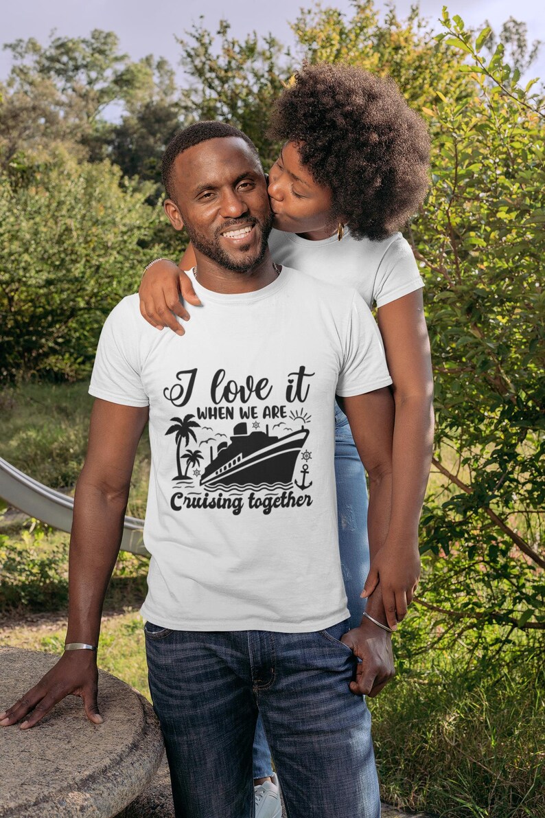 May include: A white t-shirt with a black graphic of a cruise ship and palm trees. The text on the shirt reads "I love it when we are cruising together".