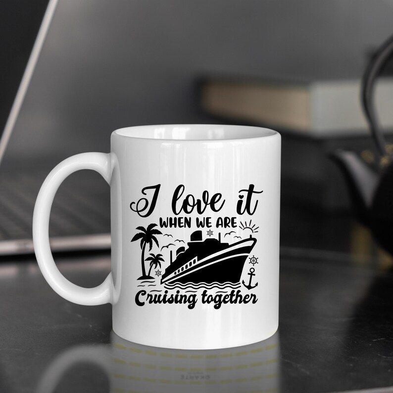 May include: White ceramic coffee mug with a black graphic of a cruise ship and palm trees. The text reads "I love it when we are cruising together".