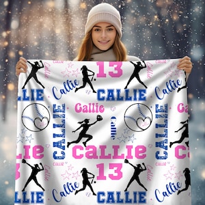 May include: White blanket with a baseball theme, featuring the name "Callie" in blue and pink, and the number 13. Includes baseball silhouettes, stars, and baseballs with hearts. A personalized gift.