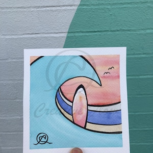 Puede incluir: Una pintura de acuarela de una tabla de surf en una ola. La ola es azul y verde, y la tabla de surf es rosa y blanca. Hay pájaros volando en el cielo sobre la ola.