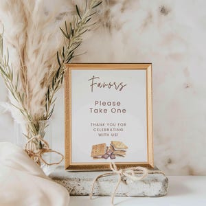 May include: A gold framed sign with the text "Favors Please Take One Thank you for celebrating with us!" and a watercolor illustration of s'mores.