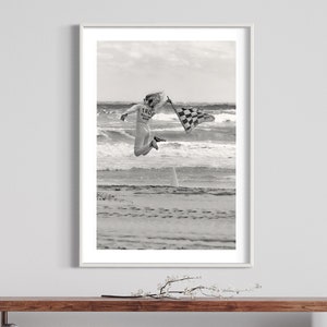 Dynamic Start at TROG: Adrenaline-Packed Flag Girl Soars Over Beach - Breathtaking Black & White Energy Photo Poster Print