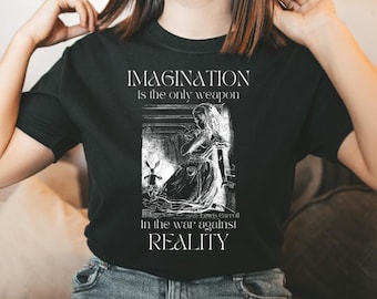 May include: Black t-shirt with a white graphic print featuring a quote from Lewis Carroll's Alice in Wonderland. The quote reads "Imagination is the only weapon in the war against reality."
